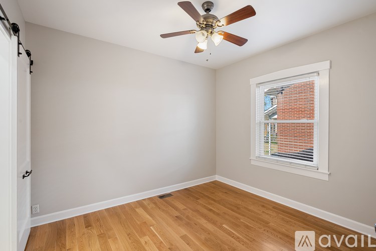 A room with a ceiling fan and a window with blinds.
