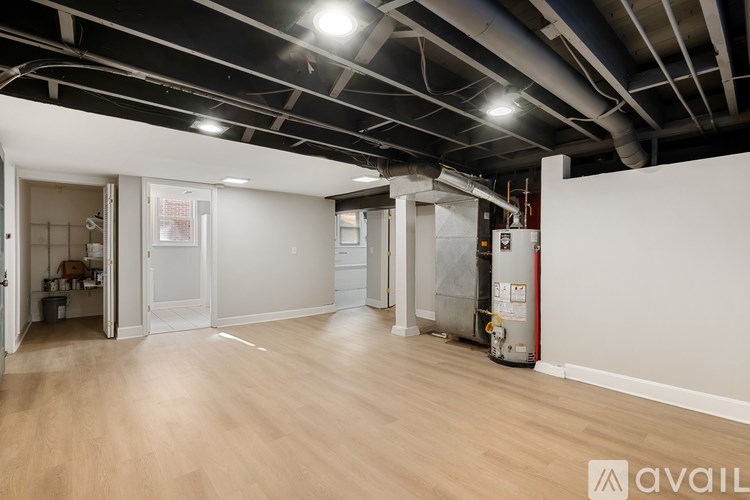 A large empty room with wooden floors and white walls.
