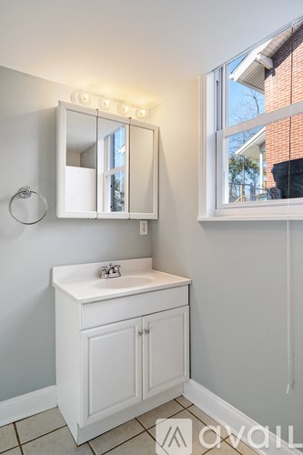 A white bathroom vanity with a mirror above it.