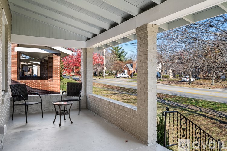A patio with a table and chairs is covered by a roof.