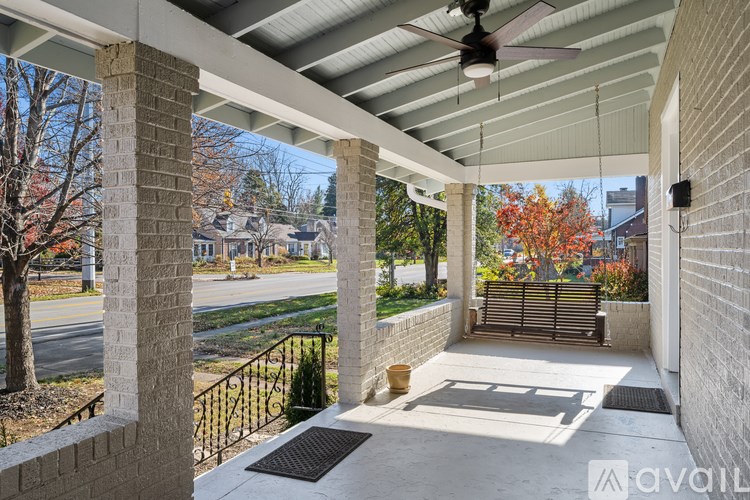 A covered patio with a ceiling fan and a view of a street.