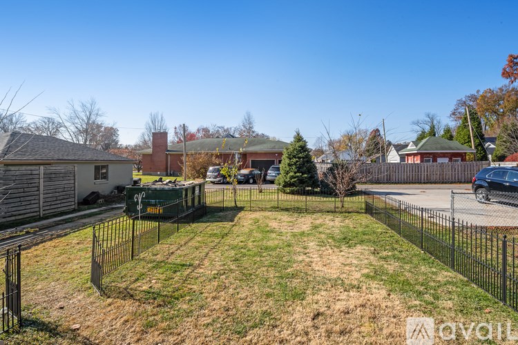 A backyard with a fence and a tree.