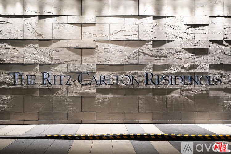 The Ritz Carlton Residences sign on a marble wall.