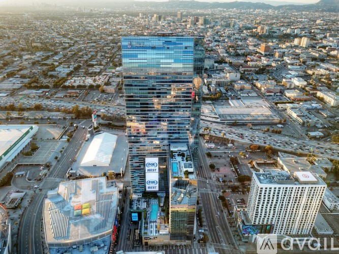 A tall building with a glass facade stands in the middle of a bustling cityscape.