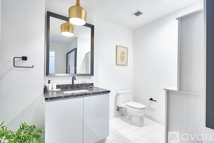 A bathroom with a sink, toilet and mirror.