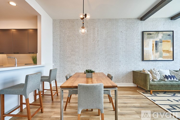 A dining room with a wooden table and grey chairs.