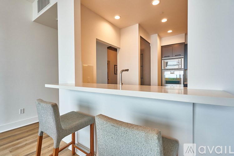 A white counter with a chair in front of it.