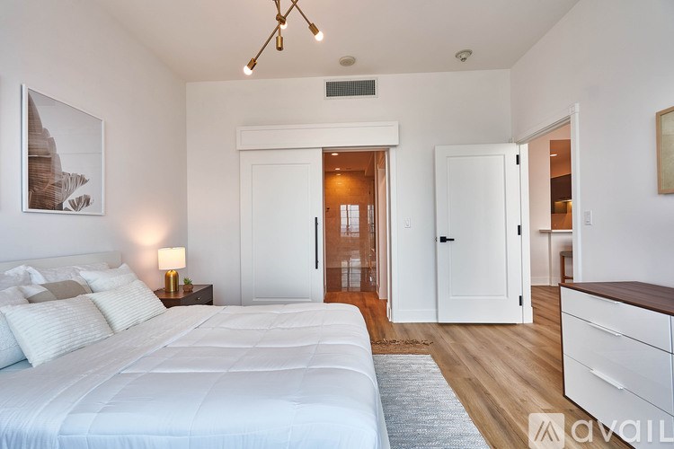 A bedroom with a large bed and a wooden floor.