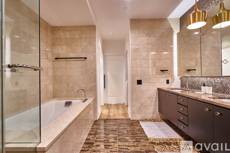 A bathroom with a glass shower stall and a bathtub, a sink, and a mirror.