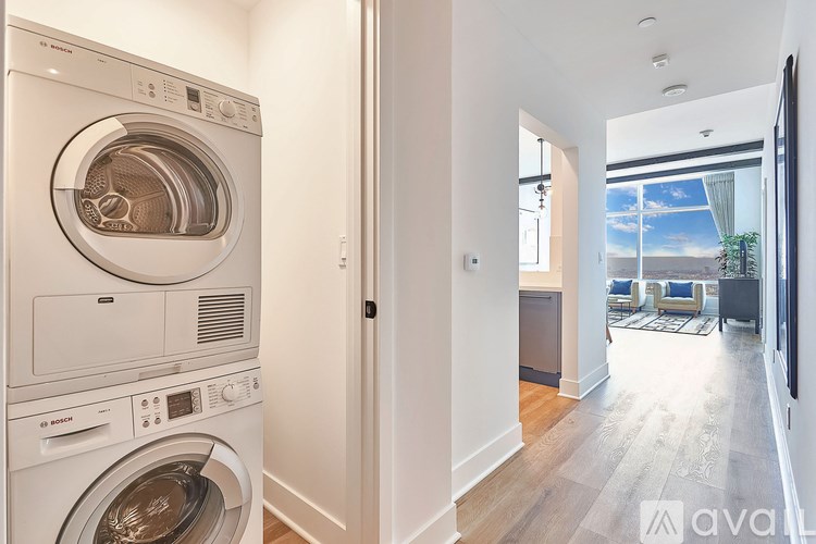 A white washing machine and dryer stacked on top of each other in a laundry room.