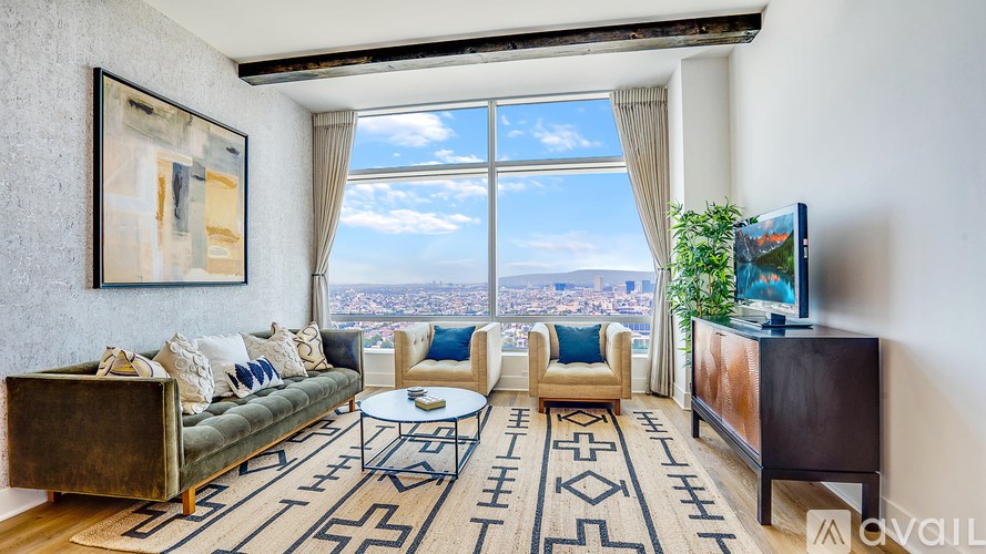 A living room with a large window overlooking a cityscape.