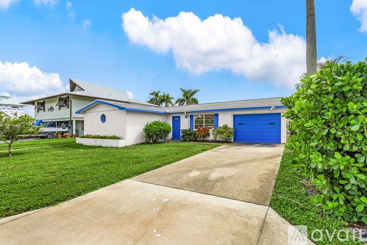 A house with a blue garage door and a white wall.