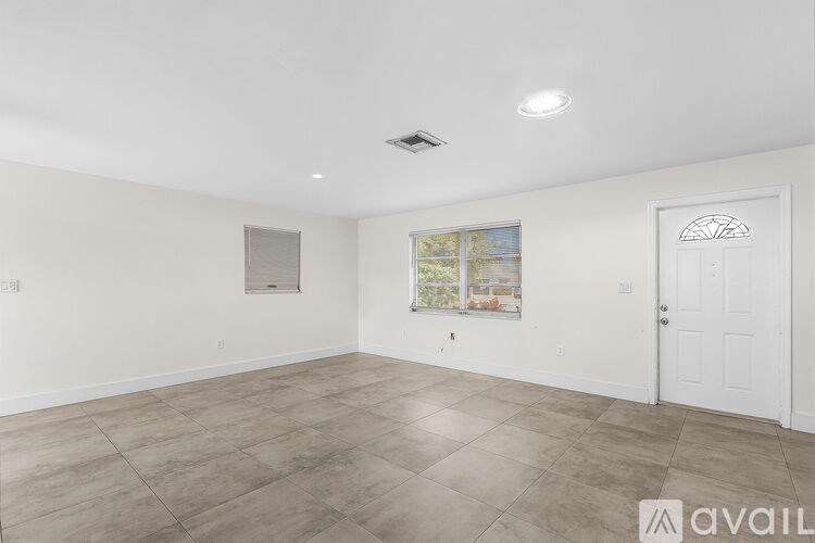 A spacious room with a large window and a door.