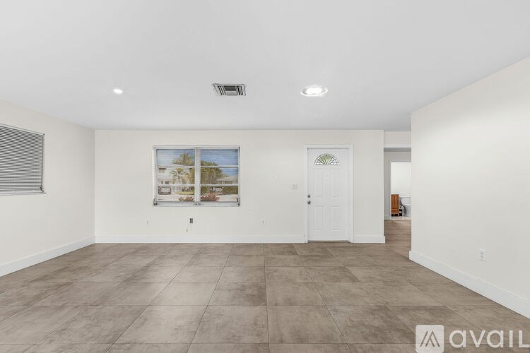 A spacious room with a large window and a door is available for rent.