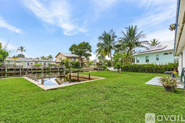 A house with a yard and a pond in front of it.