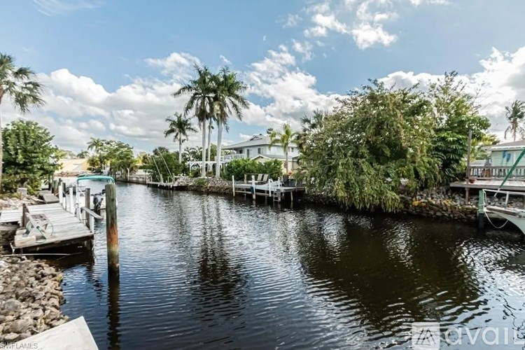 A calm water body surrounded by green trees and buildings.