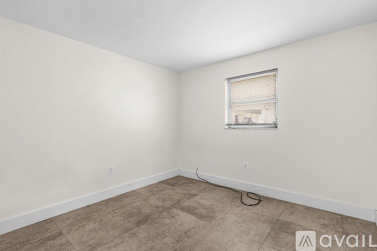 A room with a window and a tiled floor.