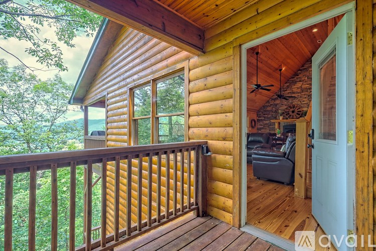 A wooden cabin with a balcony and a view of trees.