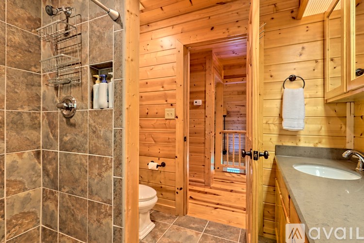 A bathroom with a wooden wall and a tiled shower.