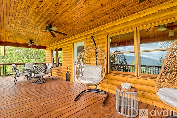 A wooden deck with a table and chairs and a ceiling fan.