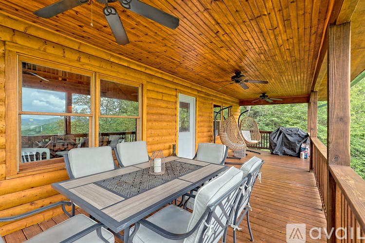 A wooden cabin with a table and chairs on the deck.