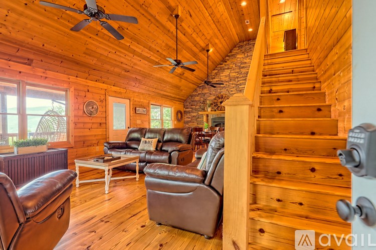 A living room with wooden walls and a staircase.