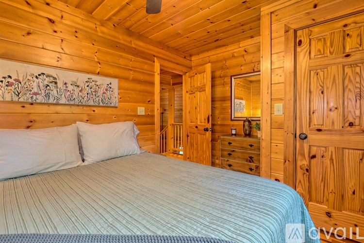 A bedroom with a bed, dresser, and wooden walls.