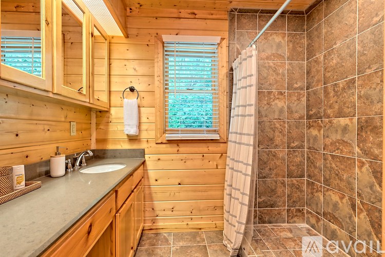 A bathroom with wooden cabinets and a tiled shower.