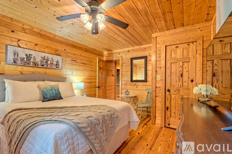 A bedroom with a bed, a chair, and a wooden door.