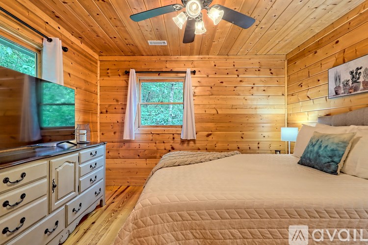 A bedroom with a bed, dresser, and window.