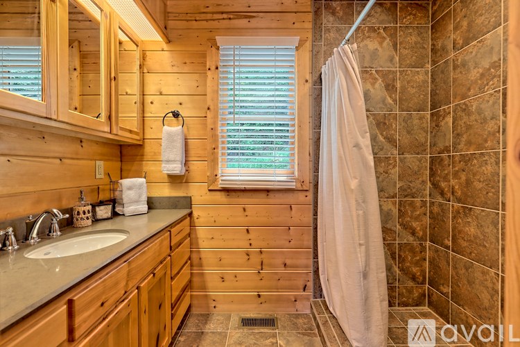 A bathroom with wooden cabinets and a tiled shower area.