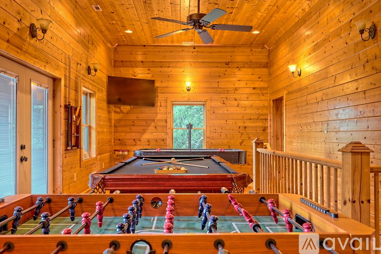 A foosball table is in the middle of a room with wood paneling.