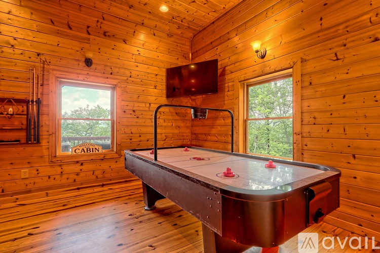 A pool table in a wooden room with a window.