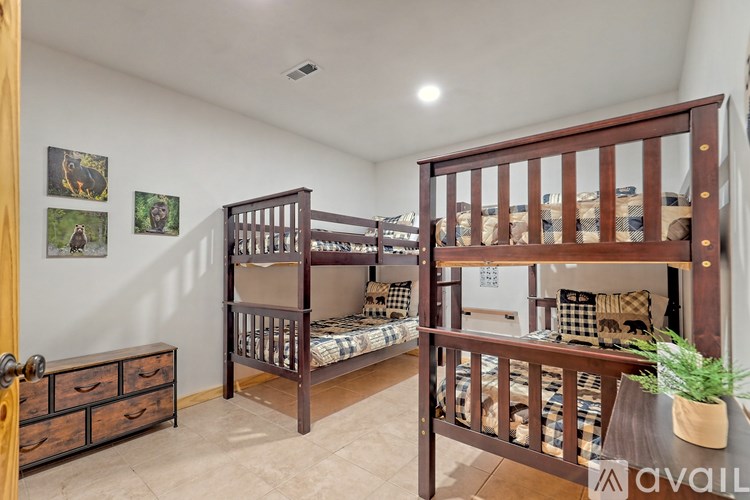 A room with two bunk beds and a dresser.