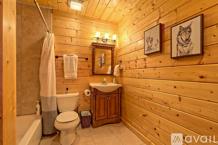 A bathroom with wooden walls and a white toilet.