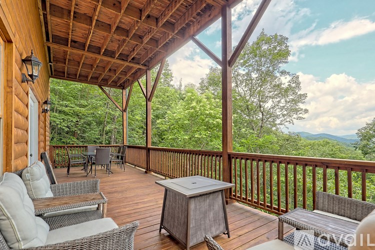 A wooden deck with a table and chairs overlooking a forest.