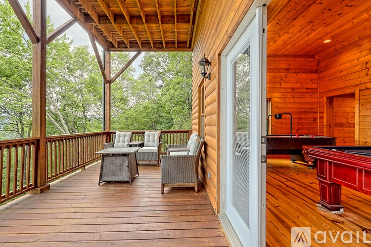 A wooden deck with a pool table and chairs.
