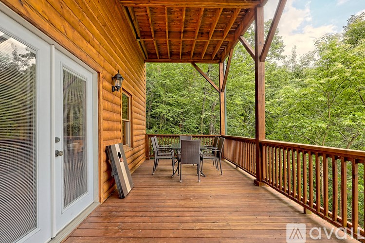 A wooden deck with a table and chairs overlooking a forest.