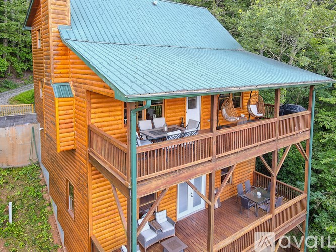 A wooden cabin with a green roof and a balcony.