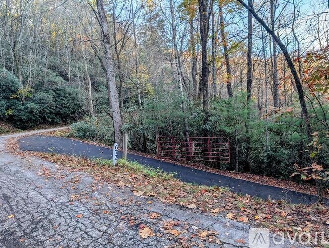 A path in a wooded area with a fence on the right side.