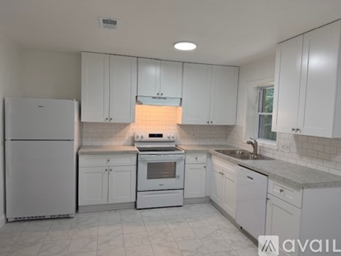 A kitchen with white appliances and cabinets.