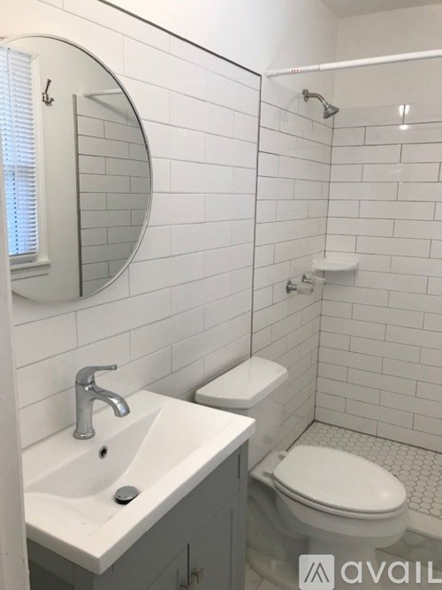 A bathroom with a sink, toilet, and mirror.