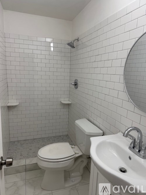 A white toilet and sink in a tiled bathroom.