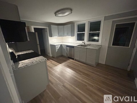 A kitchen with wooden floors and white cabinets is available for rent.