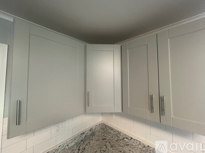 A kitchen with white cabinets and a granite countertop.