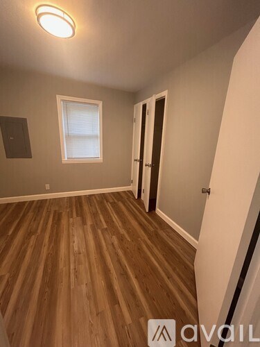 A room with wooden flooring and a window.