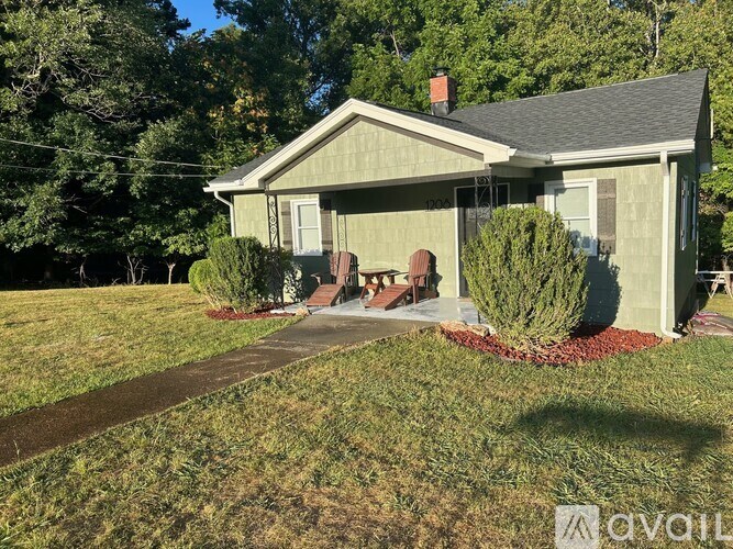 A house with a lawn and trees in the background.
