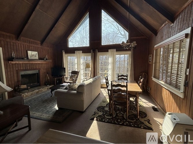 A cozy living room with a fireplace and a large window.