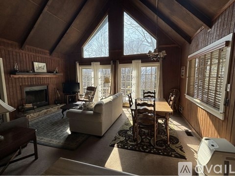 A cozy living room with a fireplace and a large window.