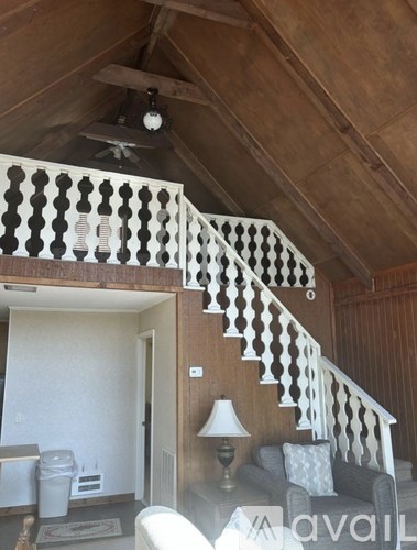 A wooden staircase with a white railing and a light on the side.